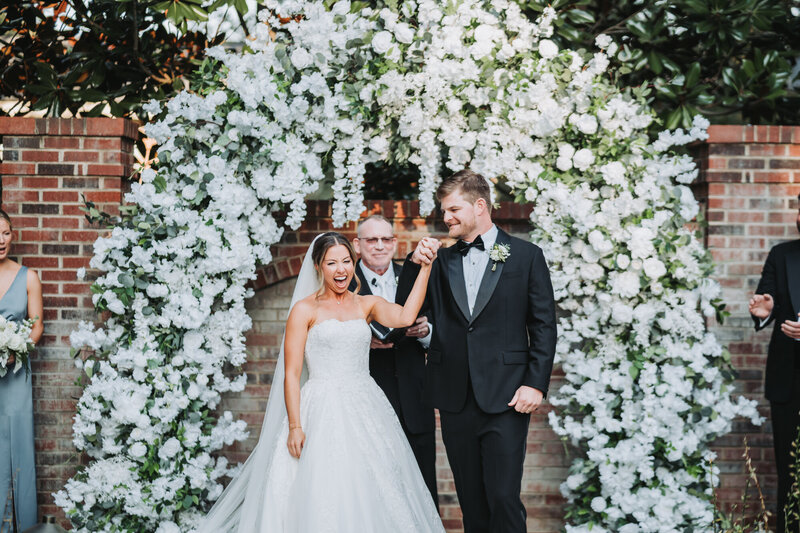 Bride and groom hold hands at wedding ceremony