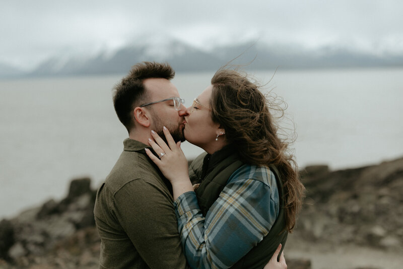 A couple kissing while the wind blows their hair.