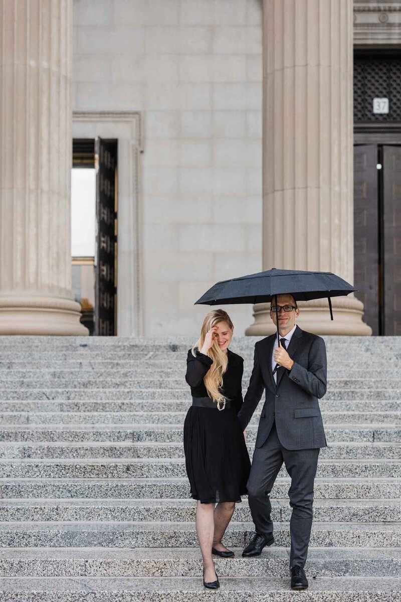 A couple take engagement photos in the rain at Chicago's Museum of Science and Industry