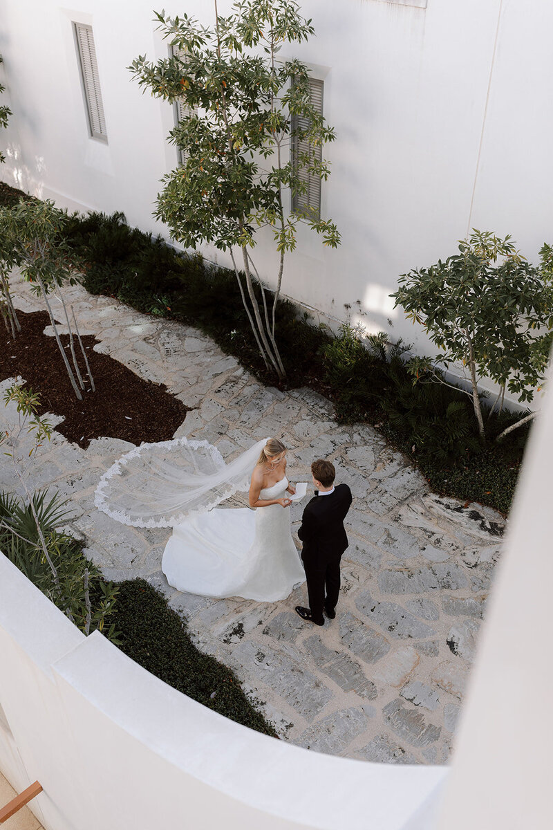 Bride and groom reading private vows in Alys Beach Courtyard 