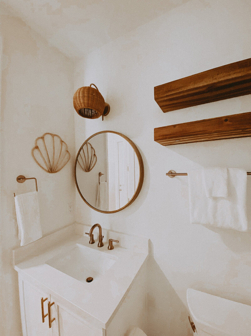 white bathroom sink with a wooden mirror