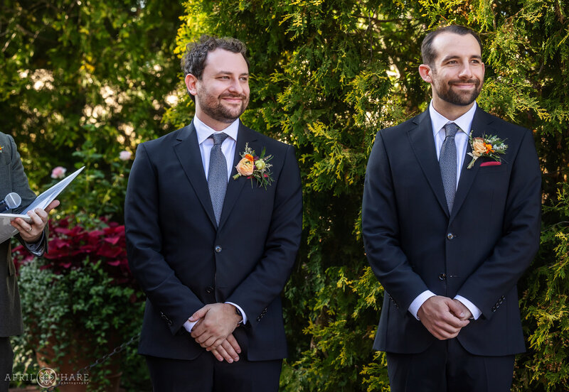 Groom looks at his bride as she walks down the aisle at the Romantic Gardens in Denver Botanic Gardens