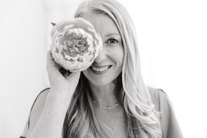 personal brand ing image of woman holding a flower by her eye