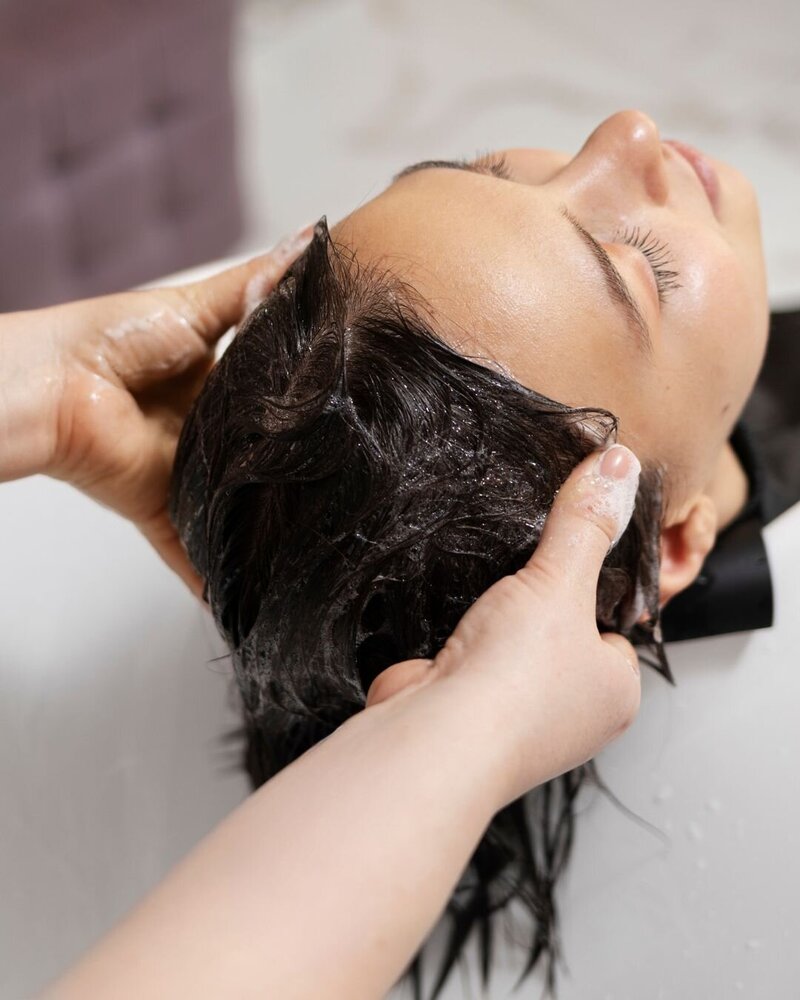 Close up of a woman receiving a scalp health treatment.