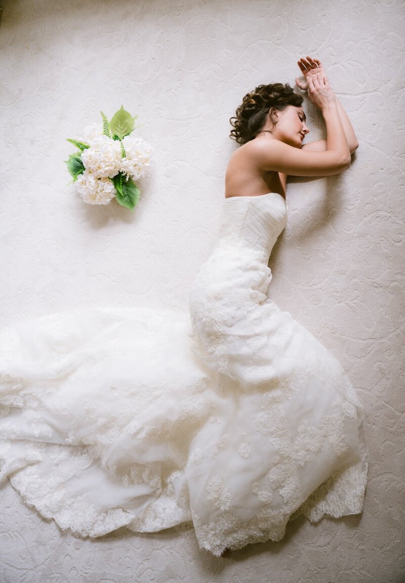 Bride holding a bouquet with her bride standing beside her, depicted in a black and white photograph.