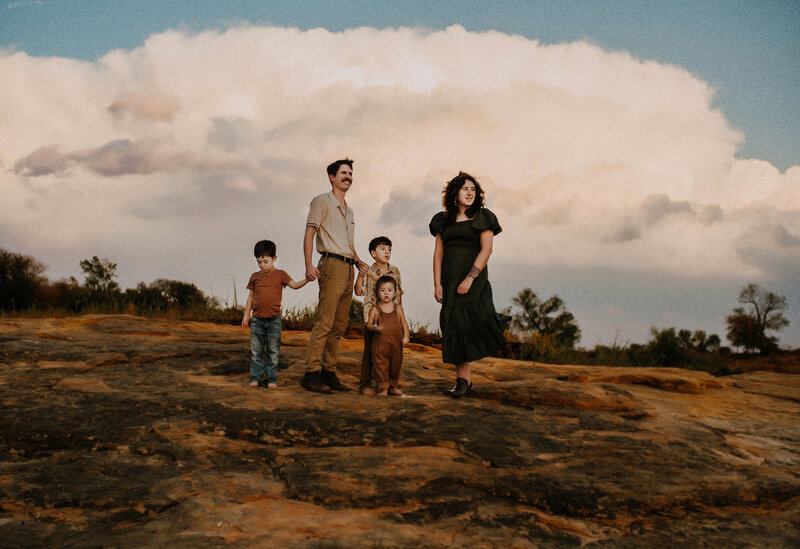 A Family of 5 standing on the rocky cliffs of lake grapevine in Flower Mound, TX looking out into the water.