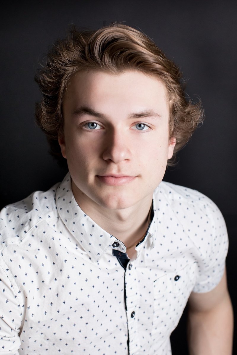 A portrait of a senior boy looking at the camera