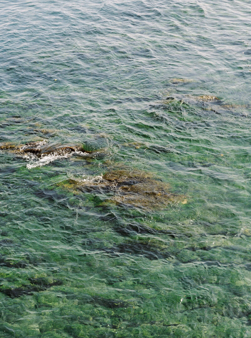 A filler image of the crystal clear water on lake como in Italy flowing over a rock