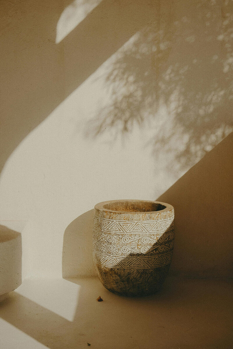 A pot on a table in front of a wall, suggesting a calm and inviting space for therapy sessions with Erin.