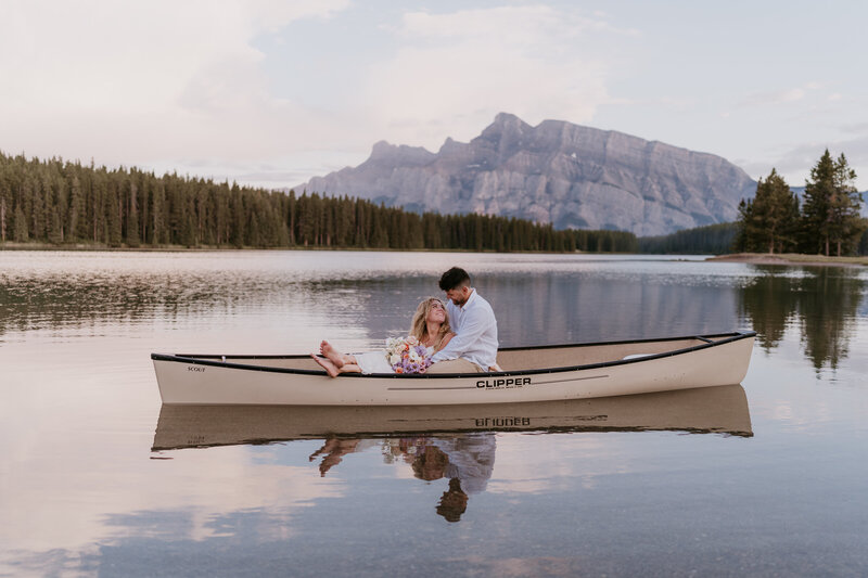 Married couple sitting together in a canoe at Two Jack Lake