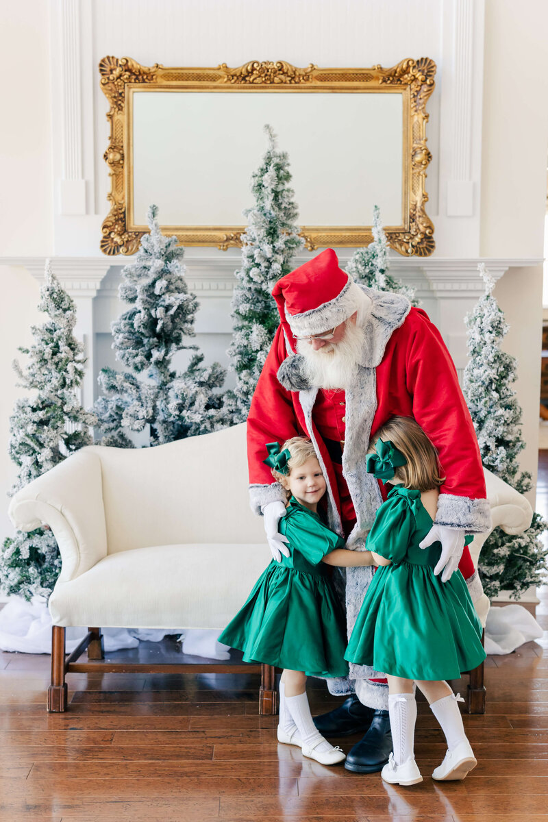 Two girls hugging santa during santa mini session at dothan alabama photography studio