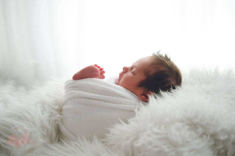 profile of baby boy swaddled in white