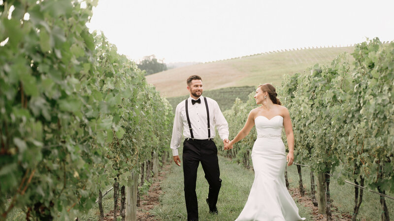 A couple walks hand in hand at Veritas Vineyards