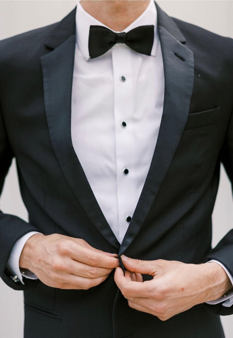 Groom wearing black suit with floral corsage