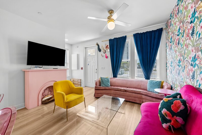 Colorful living area with velvet couch, smart TV, and vibrant decor—ideal for relaxing after a beach day in Panama City Beach or exploring 30A.