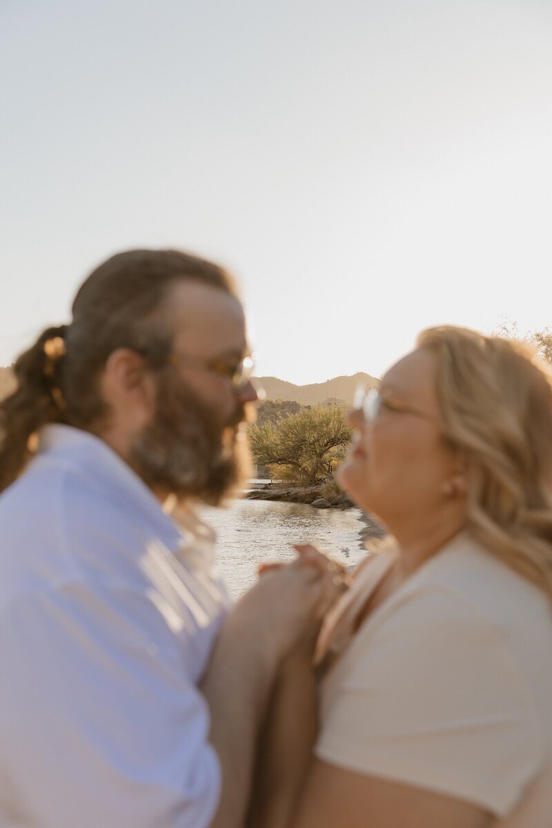 couple holds hands next to lake in arizona