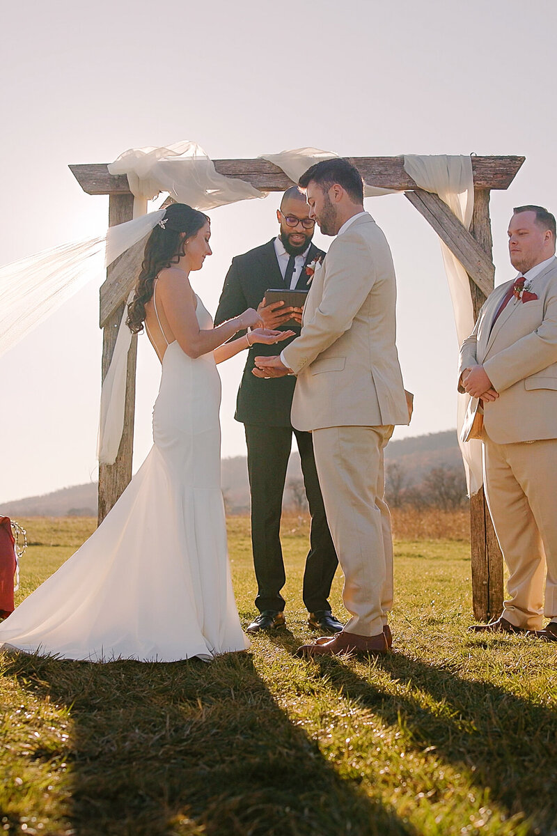 Wedding video still image of Bride and Groom exchange wedding rings during beautiful wedding ceremony at sunset