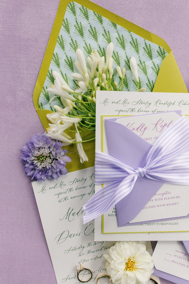 a purple and green invitation suite
