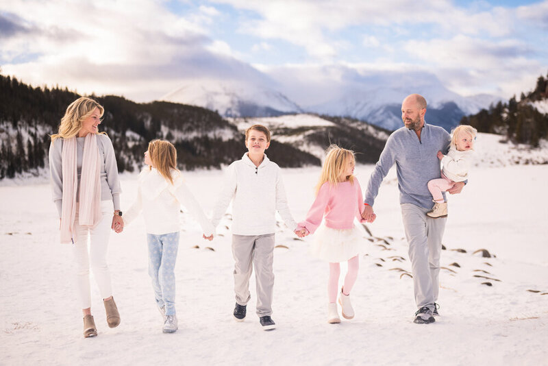 A family walks together holding hands on the snow