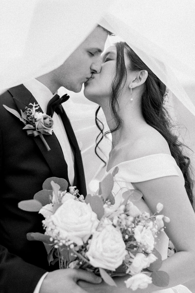 Bride and Groom kissing under the wedding veil. Captured by Charlottesville Wedding Photographer Bethany Aubre Photography.