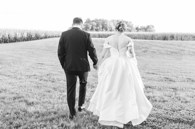 bride and groom walking while holding hands