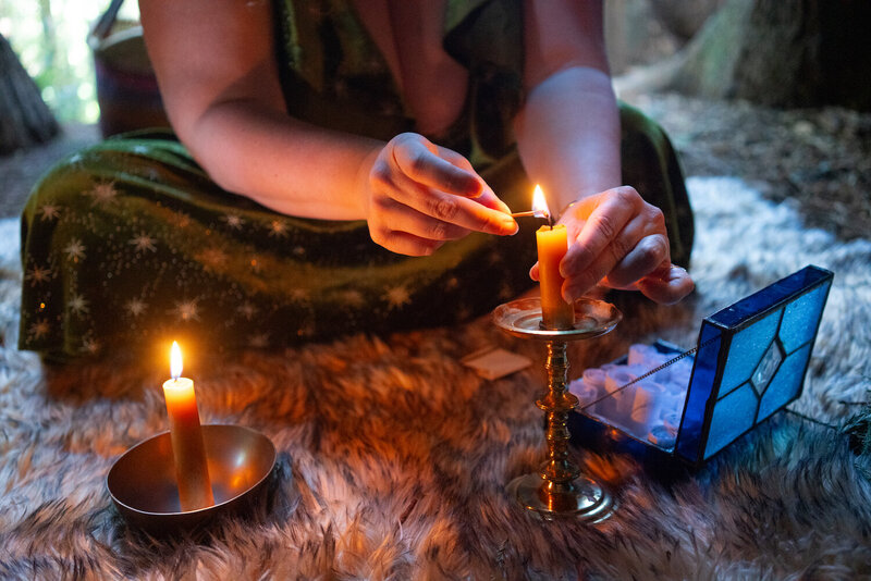 Witchy entrepreneur Rachael Maddox lighting a candle, offering The Business Witchery CEO Coven—a 12-month mastermind for seasoned biz witches to expand impact and income.