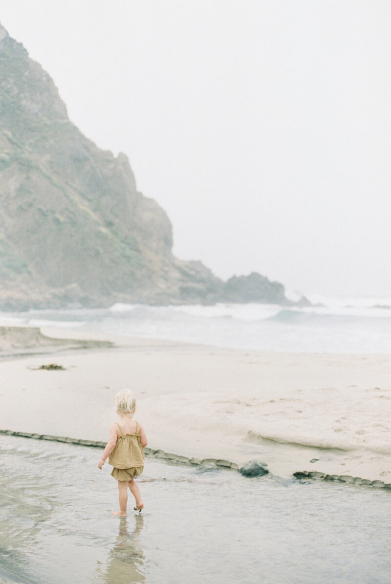 A child walking by the sea, enjoying the peaceful surroundings and the calming rhythm of the waves.