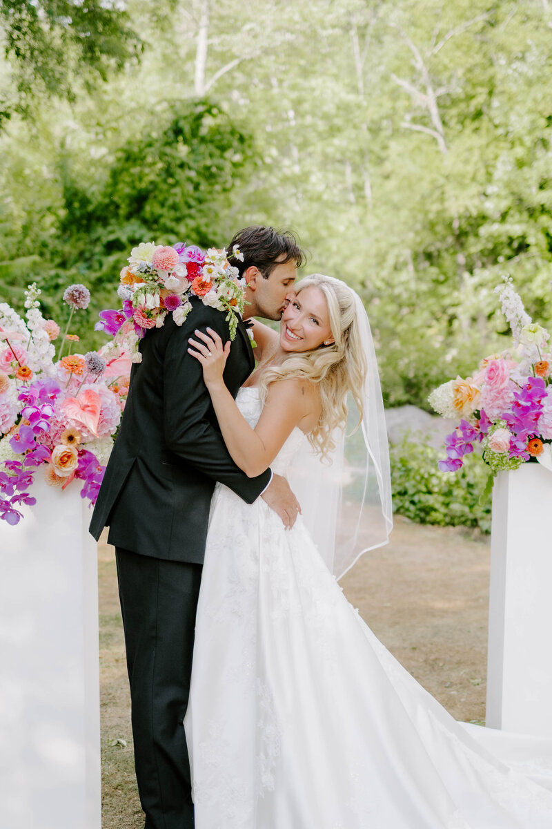 Groom dipping bride back while kissing her 