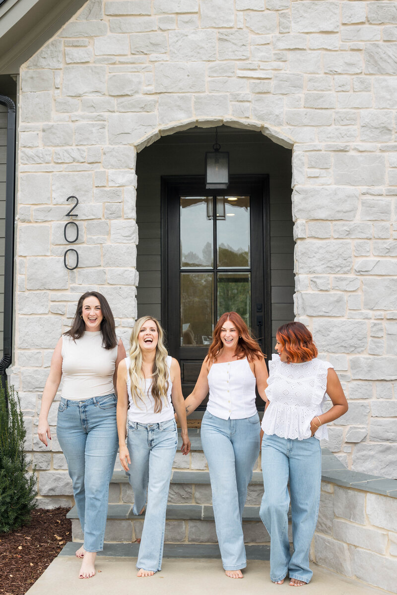 Raleigh Realtors, Jacie and Co team sitting on bed in Raleigh home for sale