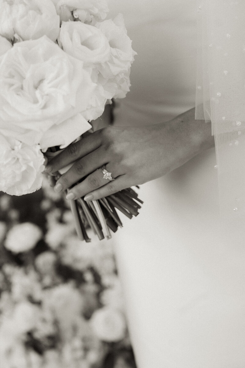 A close up of a bridal bouquet and her wedding rings,