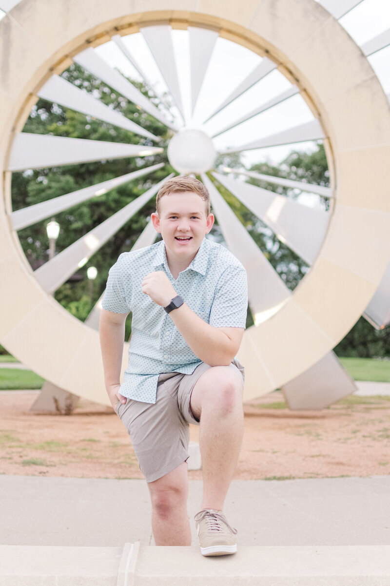 a boy posing in front of an art installation