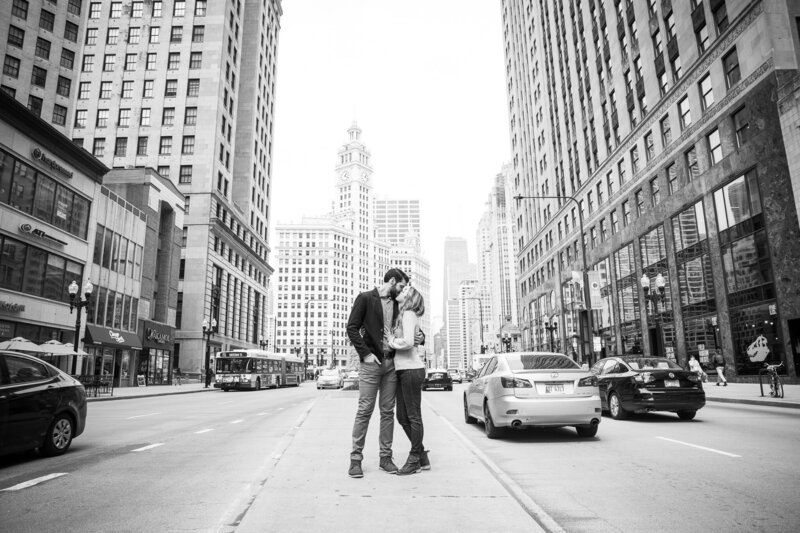 couple on michigan avenue kissing after surprise proposal in downtown chicago
