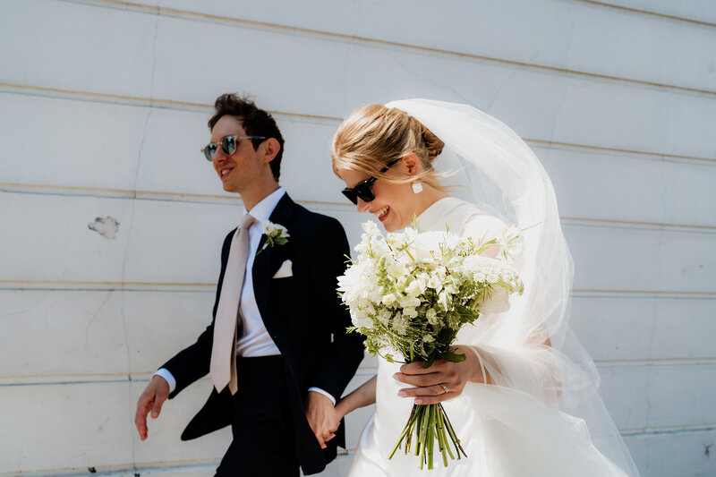 bride and groom walking and smiling captured by old marylebone town hall film documentary wedding photographer