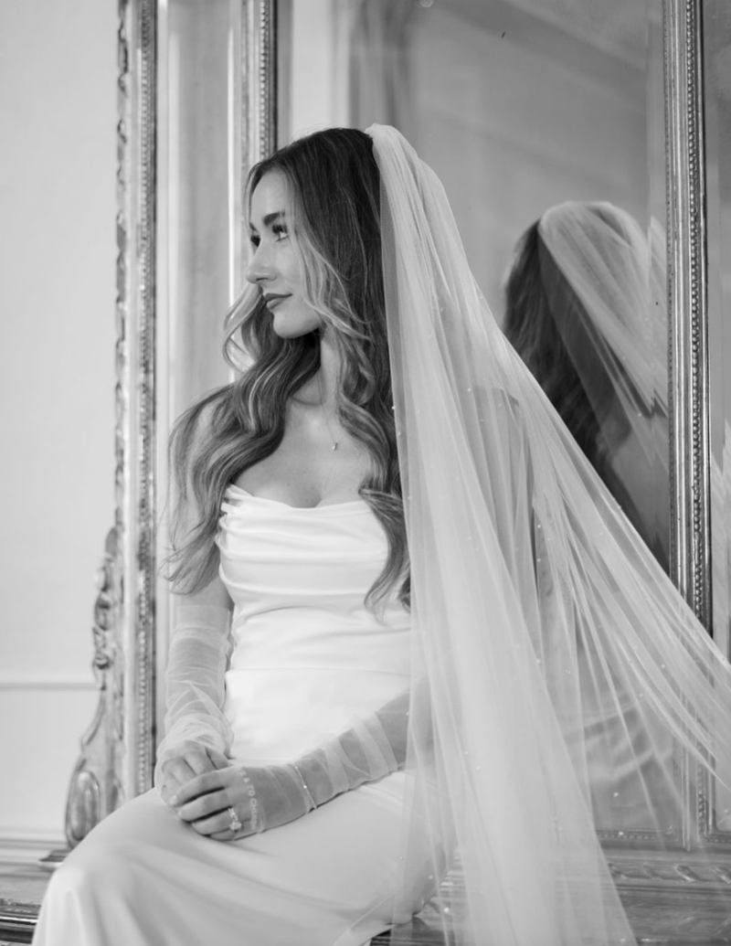 Bride in timeless, modern wedding gown with long veil at her destination wedding.