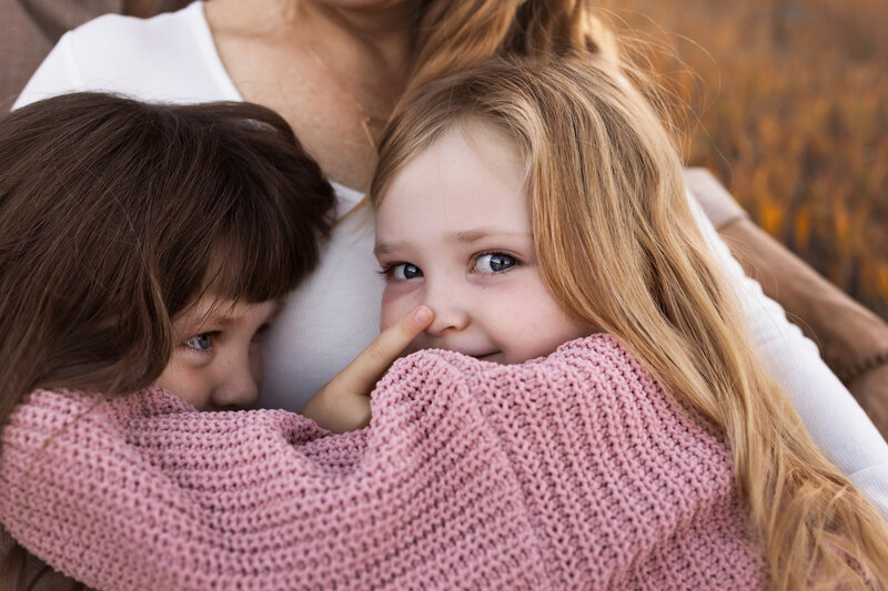 A backlit photo of a mother and her young daughter.