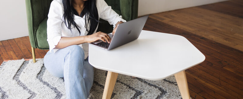 Adeola (email copywriter) typing away on her  Macbook laptop