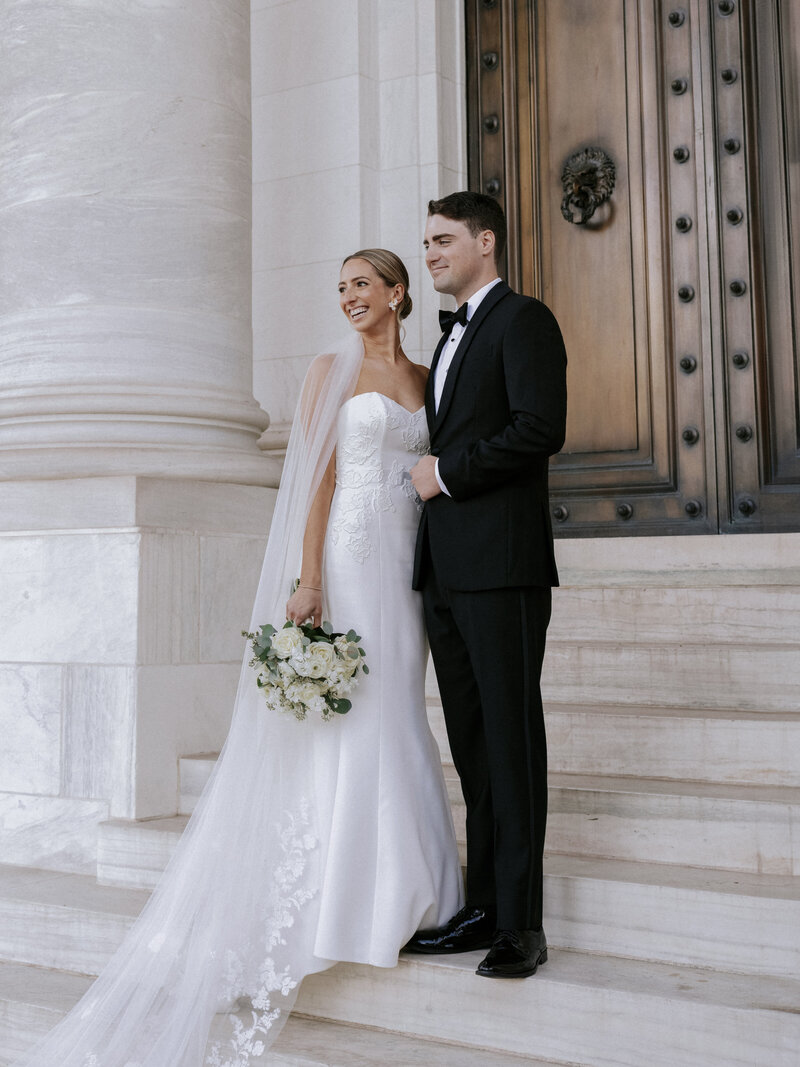 happy-bride-and-groom-looking-out-from-white-marble-monument-2