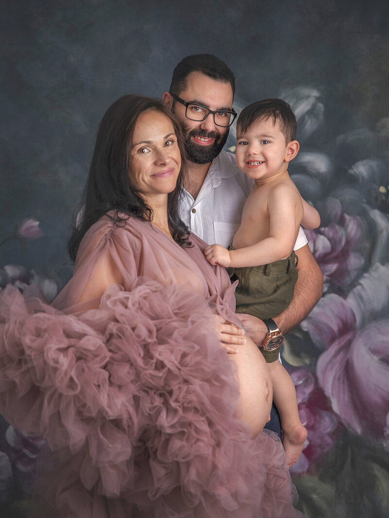 A beautiful family maternity portrait featuring parents and their child, with mom showing off her baby bump, captured in a serene photography session in Ottawa."
