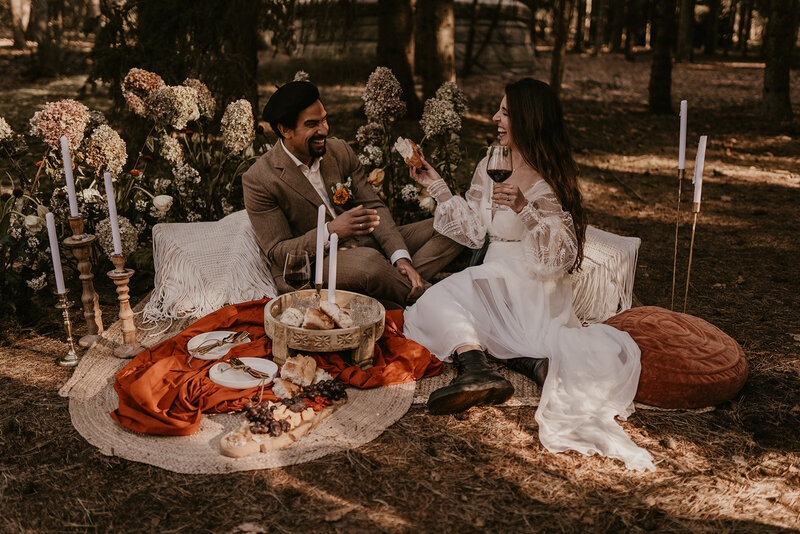 Bruidspaar met een picnic in het bos