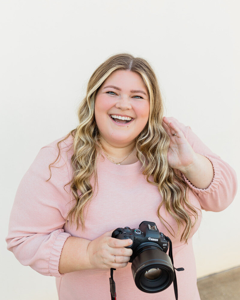 Shalae Byrd, photographer, smiles and holds camera