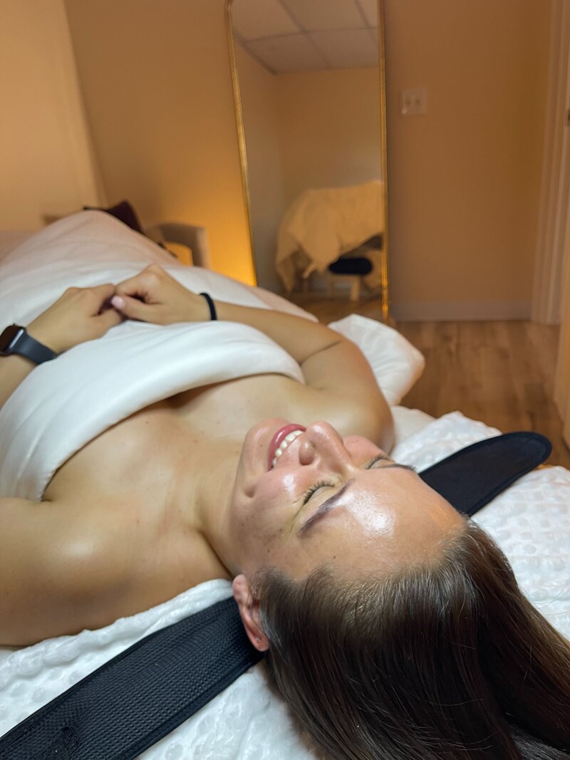 Client smiling on facial bed