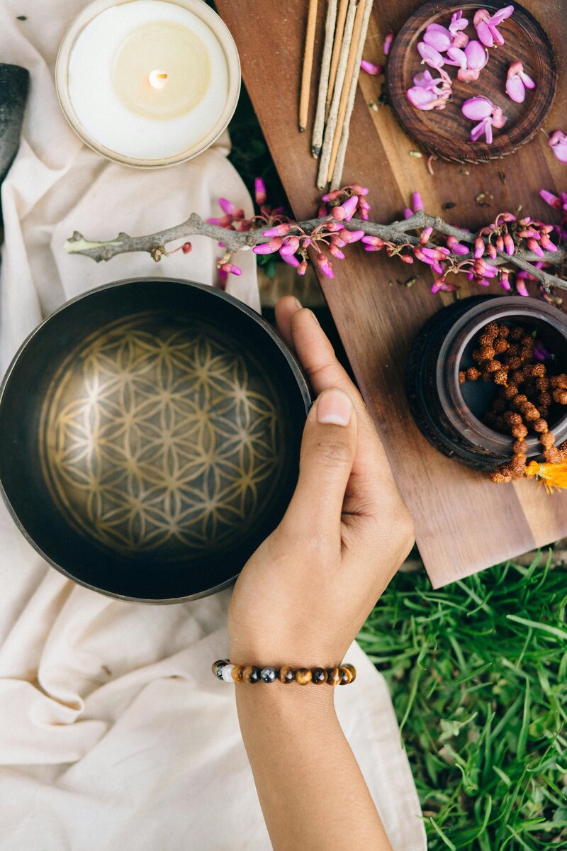 Woman's hand holding bowl with purple flowers