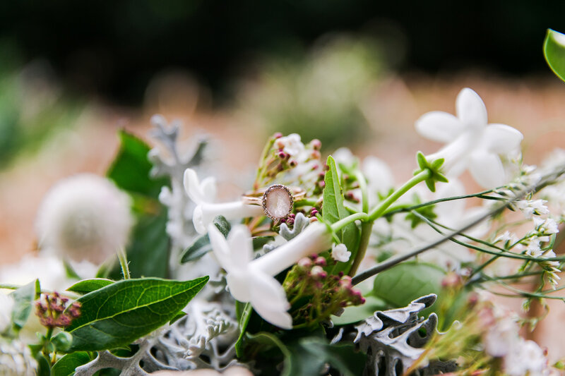Close up of wedding ring amongst flowers