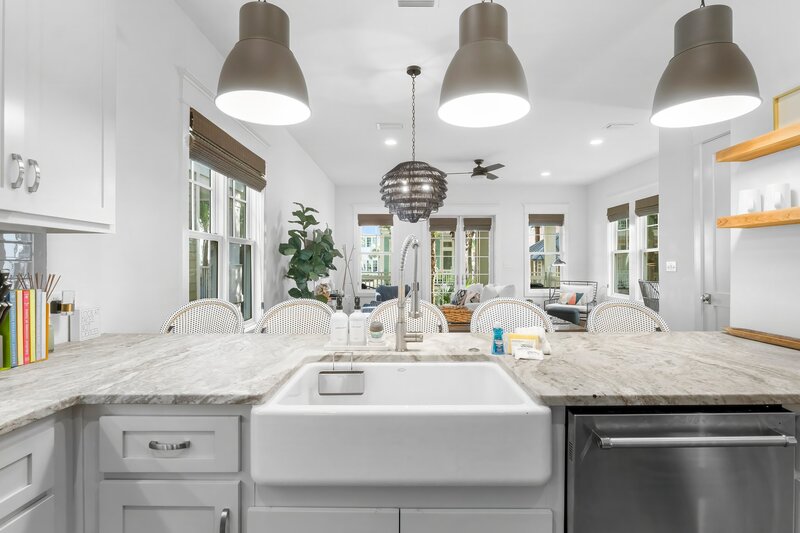 Coastal kitchen with large island, farmhouse sink, and pendant lighting in a vacation home near Panama City Beach.

