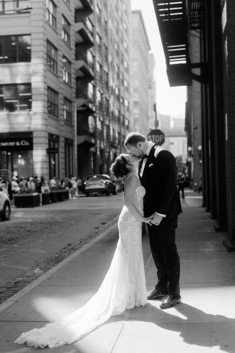 Photo of a bride and groom holding one another, laughing on the lawn of Congress Hall with the hydrangeas in bloom on the background