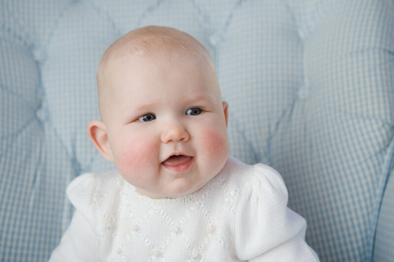 Baby sitting in chair and smiling