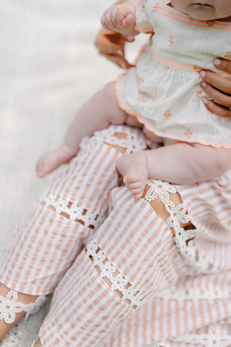 A detail photo of a baby while sitting on her mom's lap.