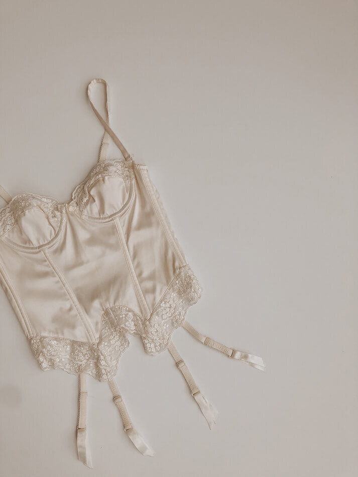 Maquette de présentation de l'identité visuelle de Cajole Lingerie, qui représente l'ambiance confortable et ensoleillée des matins au lit. L'image montre un corset de la marque.