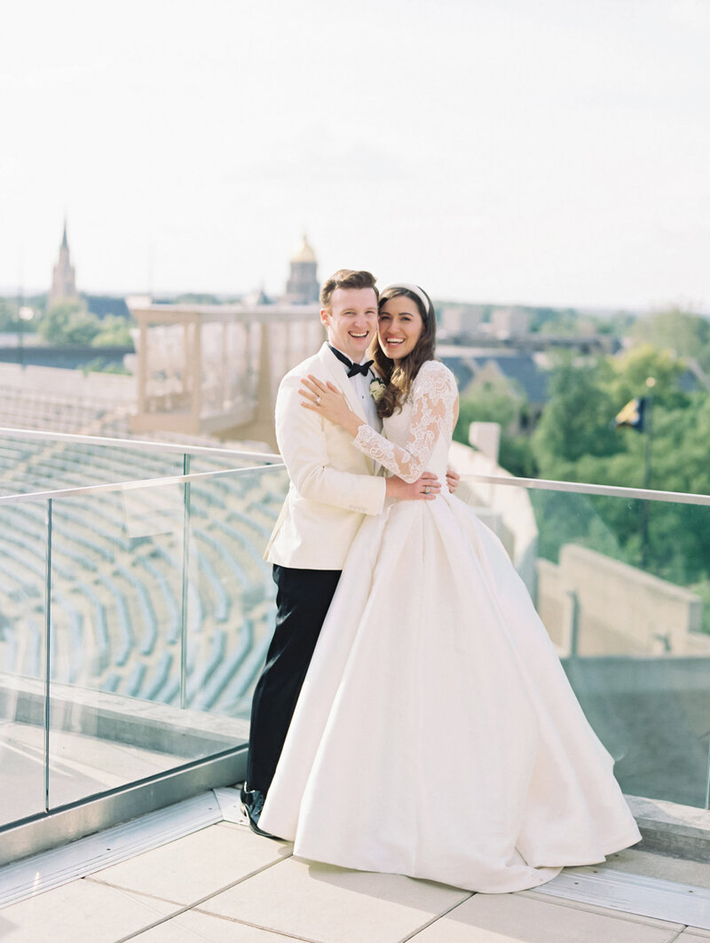 Bride and groom smiling and embracing on rooftop photographed by Chicago editorial wedding photographer Arielle Peters