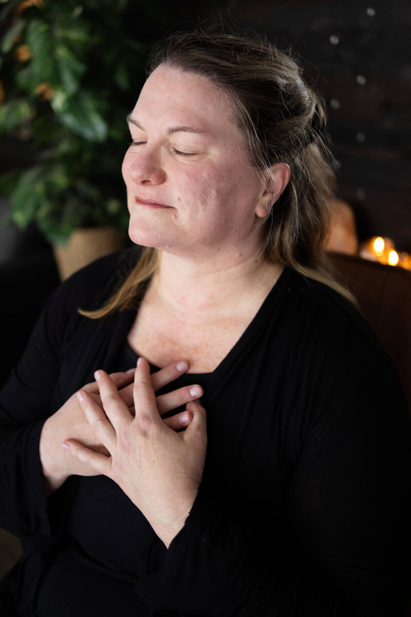Katie with hands on her heart and eyes closed.